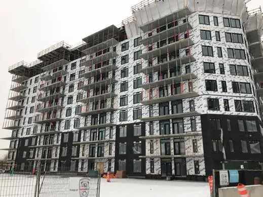 K Building Project: a large mid-rise with dark cladding on the lower floors