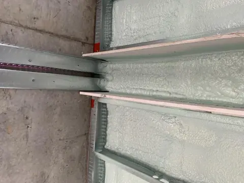Close-up of Z-bars with thermal-break strips and closed-cell foam behind the sheathing