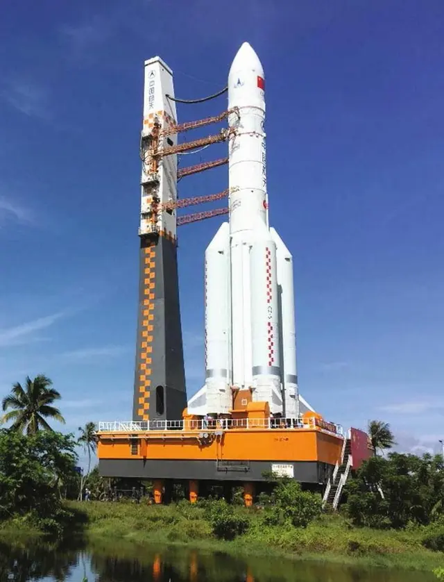 China’s white Long March 5 rocket standing on its orange mobile launch platform beside the service tower