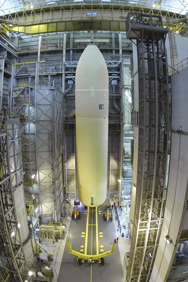 A Space Shuttle external tank standing upright in a work cell at the Michoud Assembly Facility